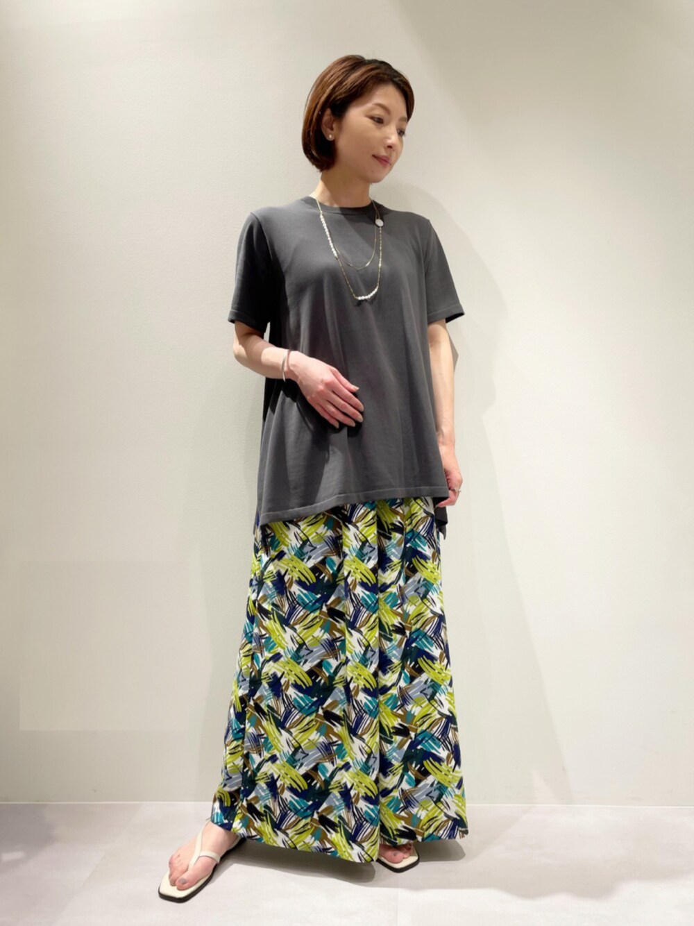 グレー系のニット/セーター、その他のその他パンツ、ゴールド系のネックレスを着用したレディースの春コーディネートの1枚目の写真