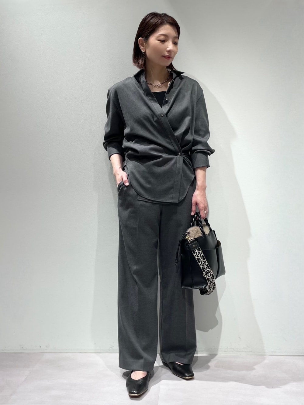 グレー系のその他パンツ、グレー系のシャツ/ブラウス、ブラック系のタンクトップを着用したレディースの秋コーディネートの1枚目の写真
