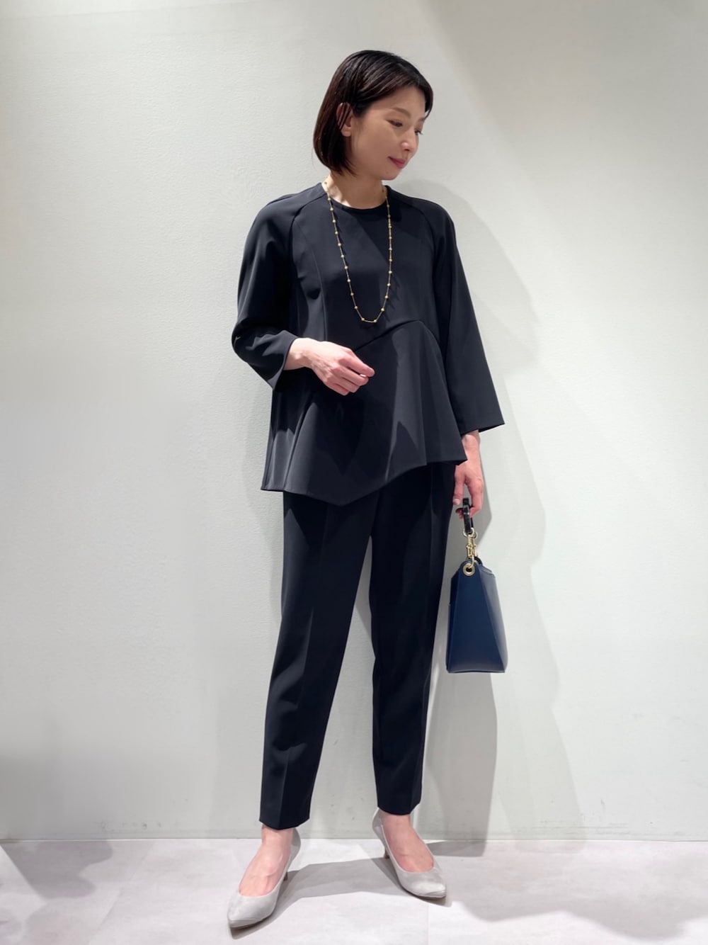 ブルー系のシャツ/ブラウス、ブルー系のスラックス、ブルー系のハンドバッグを着用したレディースの冬コーディネートの1枚目の写真