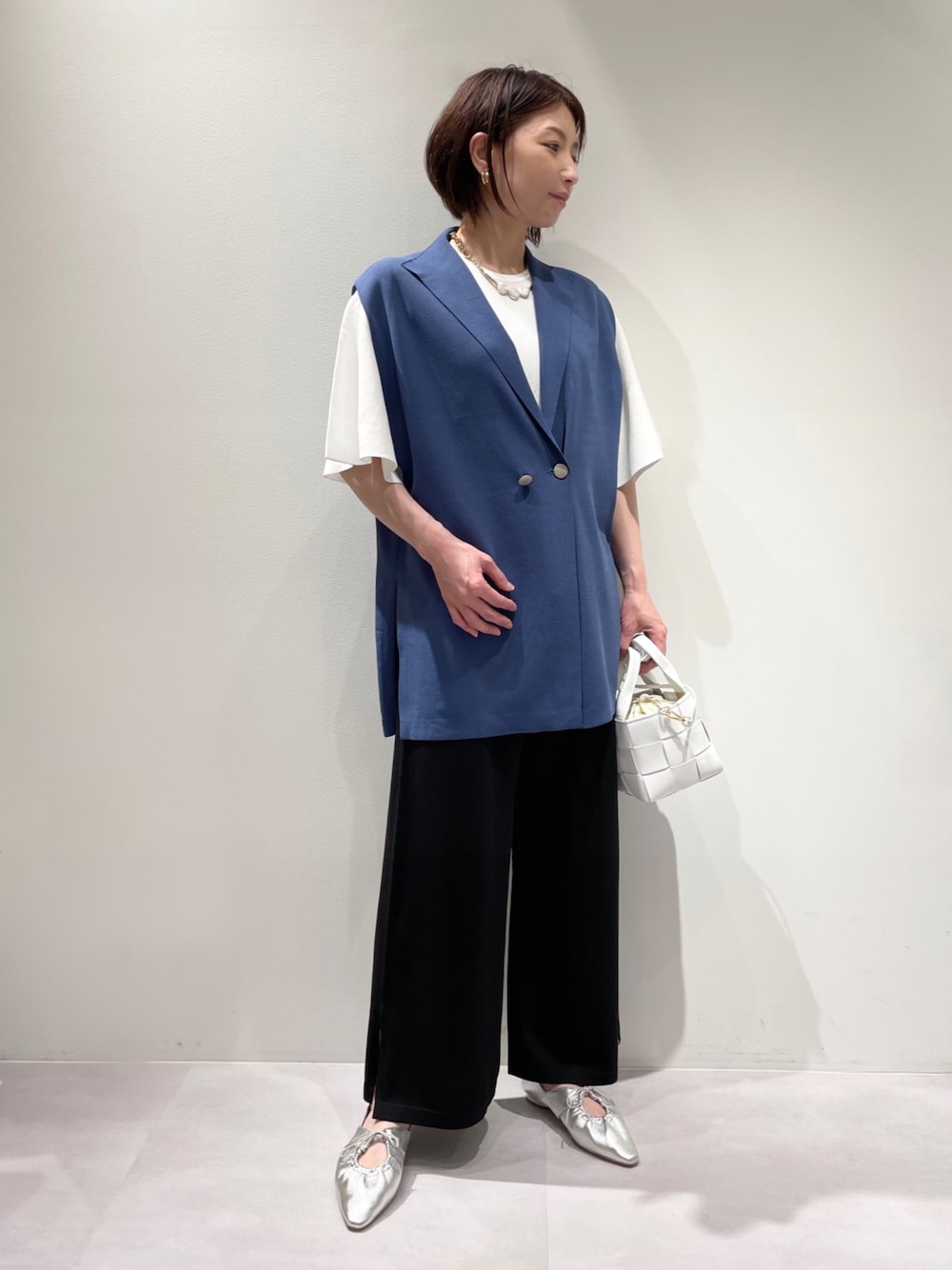 ブラック系のその他パンツ、ブルー系のニット/セーター、シルバー系のパンプスを着用したレディースの春コーディネートの1枚目の写真