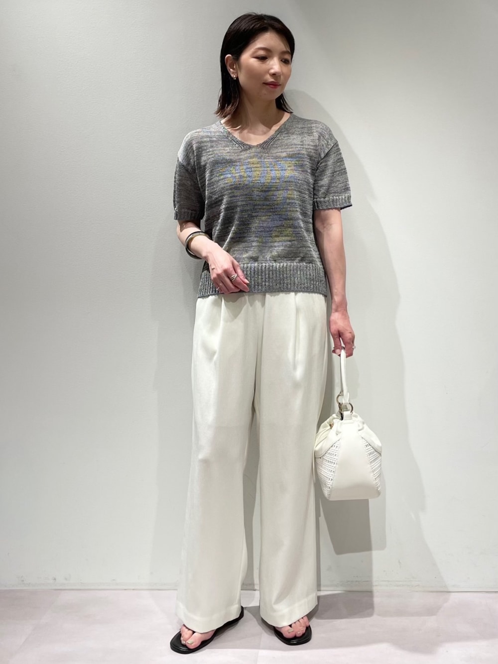 グレー系のニット/セーター、ホワイト系のその他パンツ、ブラウン系のサンダルを着用したレディースの夏コーディネートの1枚目の写真