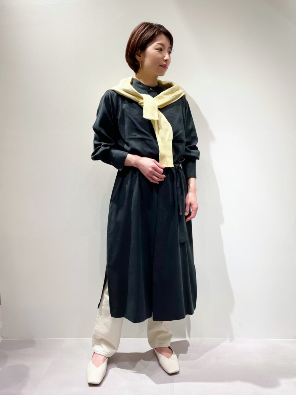 ホワイト系のパンプス、イエロー系のニット/セーター、ホワイト系のデニムパンツを着用したレディースの冬コーディネートの1枚目の写真