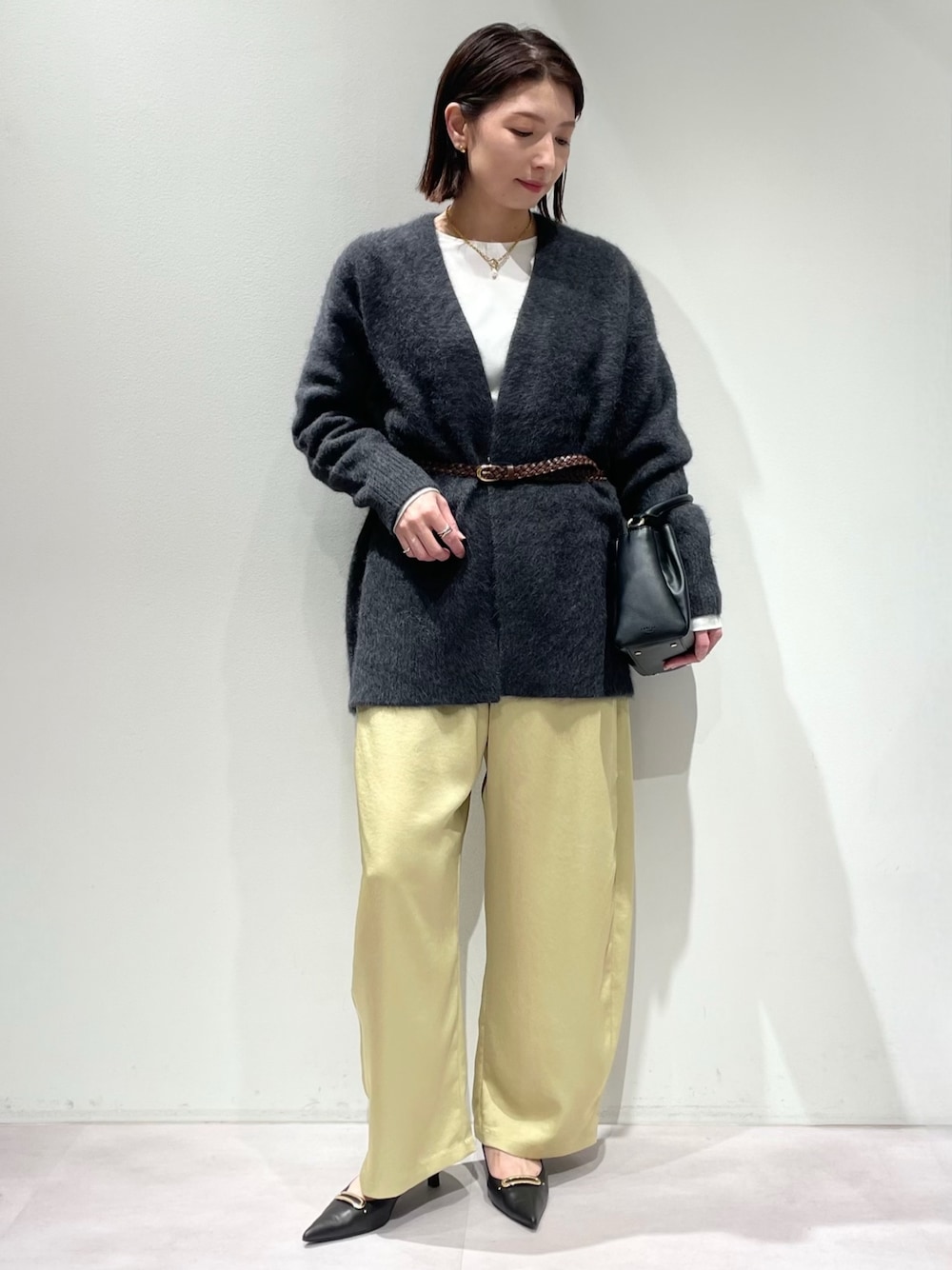 イエロー系のその他パンツ、グレー系のカーディガン/ボレロ、ホワイト系のTシャツ/カットソーを着用したレディースの秋コーディネートの1枚目の写真