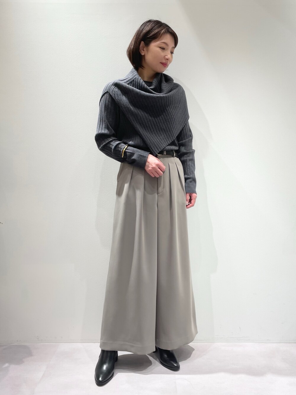 グレー系のその他パンツ、ブラック系のブーツ、グレー系のニット/セーターを着用したレディースの冬コーディネートの1枚目の写真