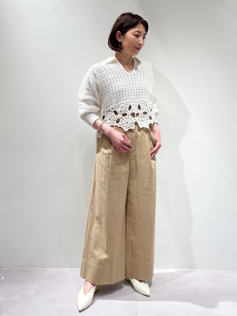 ベージュ系のその他パンツ、ホワイト系のニット/セーター、ホワイト系のパンプスを着用したレディースの冬コーディネートの1枚目の写真