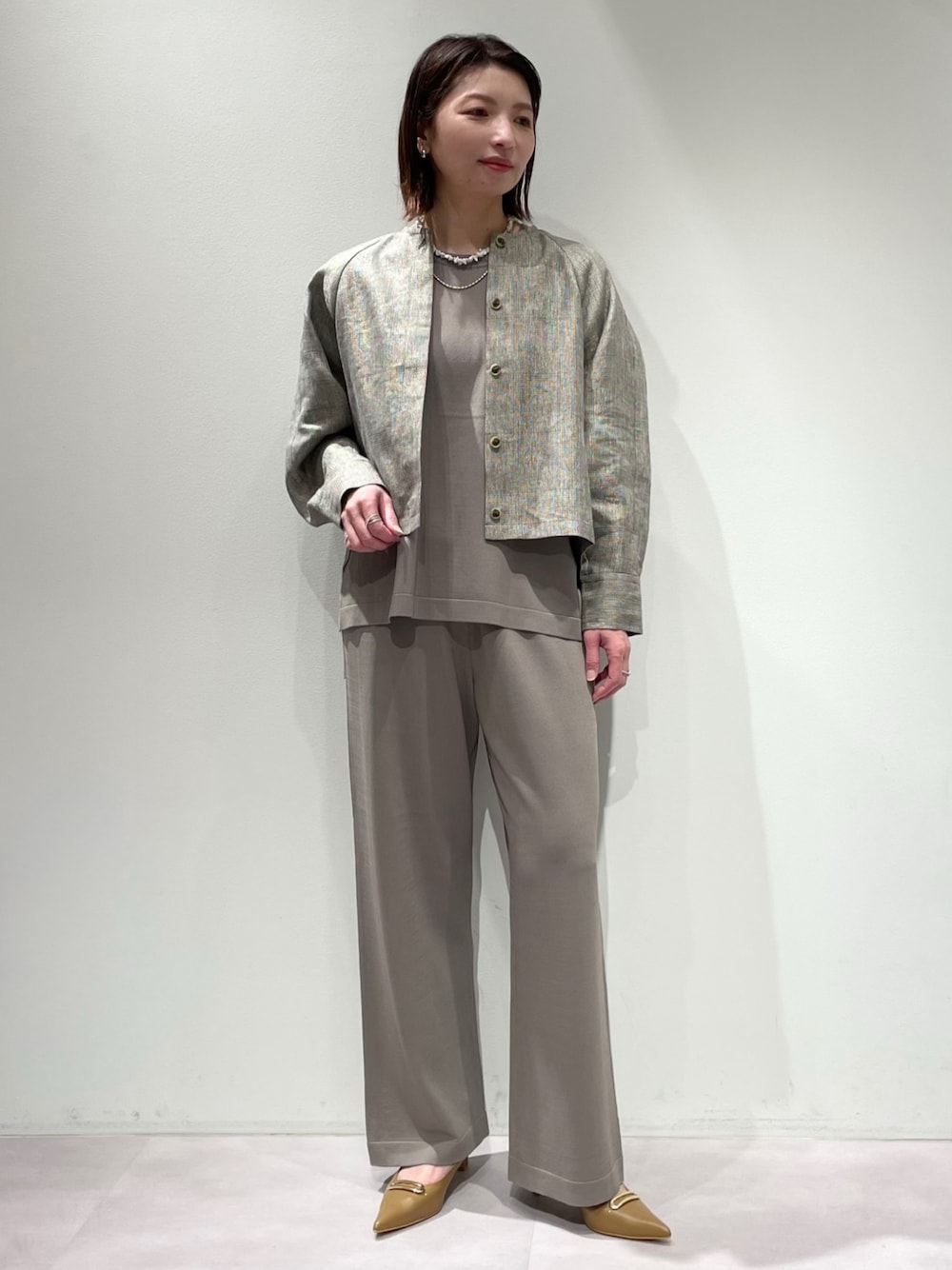 グレー系のニット/セーター、グレー系のその他パンツ、ベージュ系のブルゾンを着用したレディースの春コーディネートの1枚目の写真