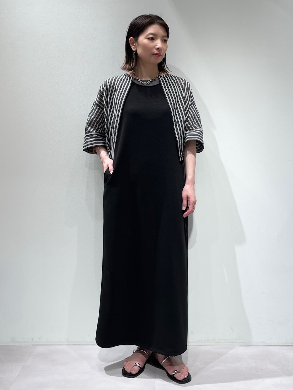 ブラック系のワンピース、ブラック系のシャツ/ブラウス、シルバー系のネックレスを着用したレディースの夏コーディネートの1枚目の写真