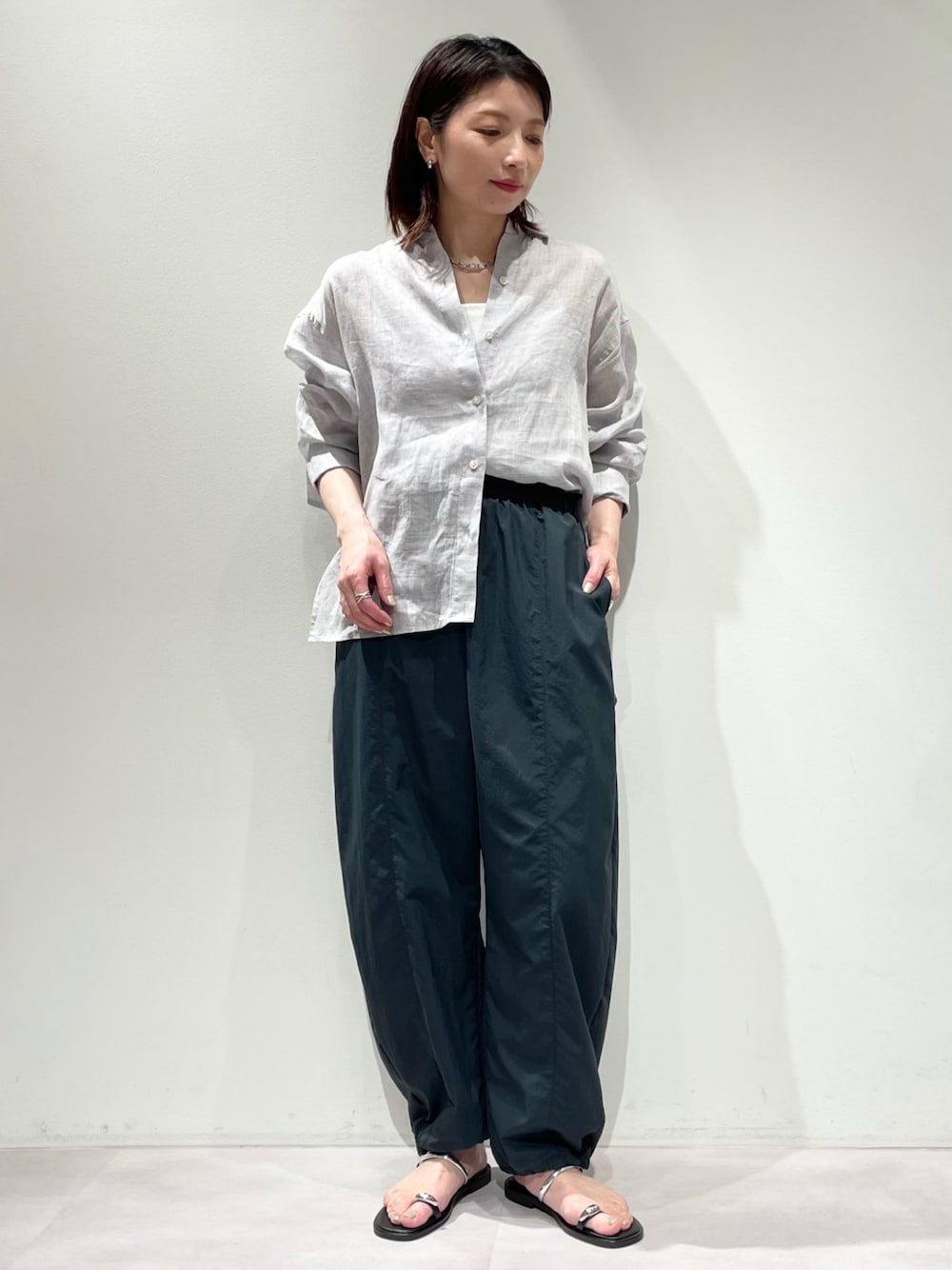 ホワイト系のニット/セーター、パープル系のシャツ/ブラウス、グレー系のその他パンツを着用したレディースの春コーディネートの1枚目の写真