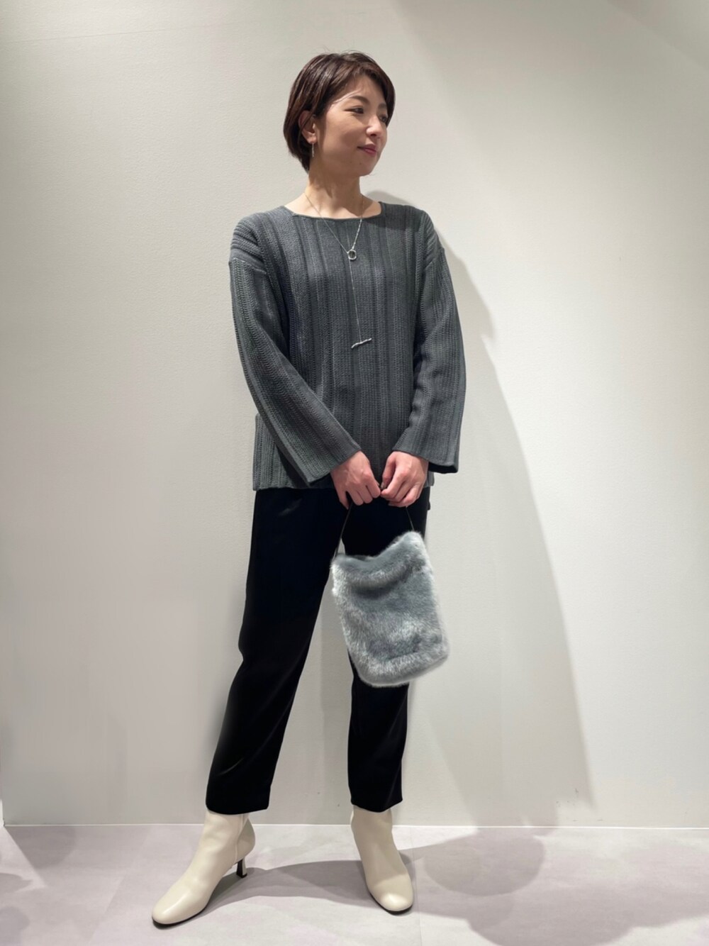 ブラック系のその他パンツ、グレー系のニット/セーター、ホワイト系のブーツを着用したレディースの冬コーディネートの1枚目の写真