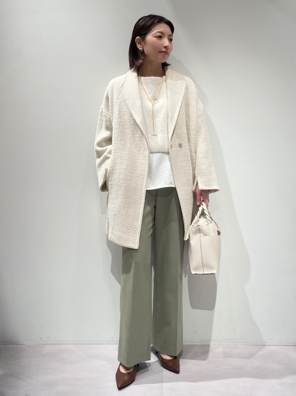 グリーン系のその他パンツ、ホワイト系のニット/セーター、ホワイト系のタンクトップを着用したレディースの冬コーディネートの1枚目の写真