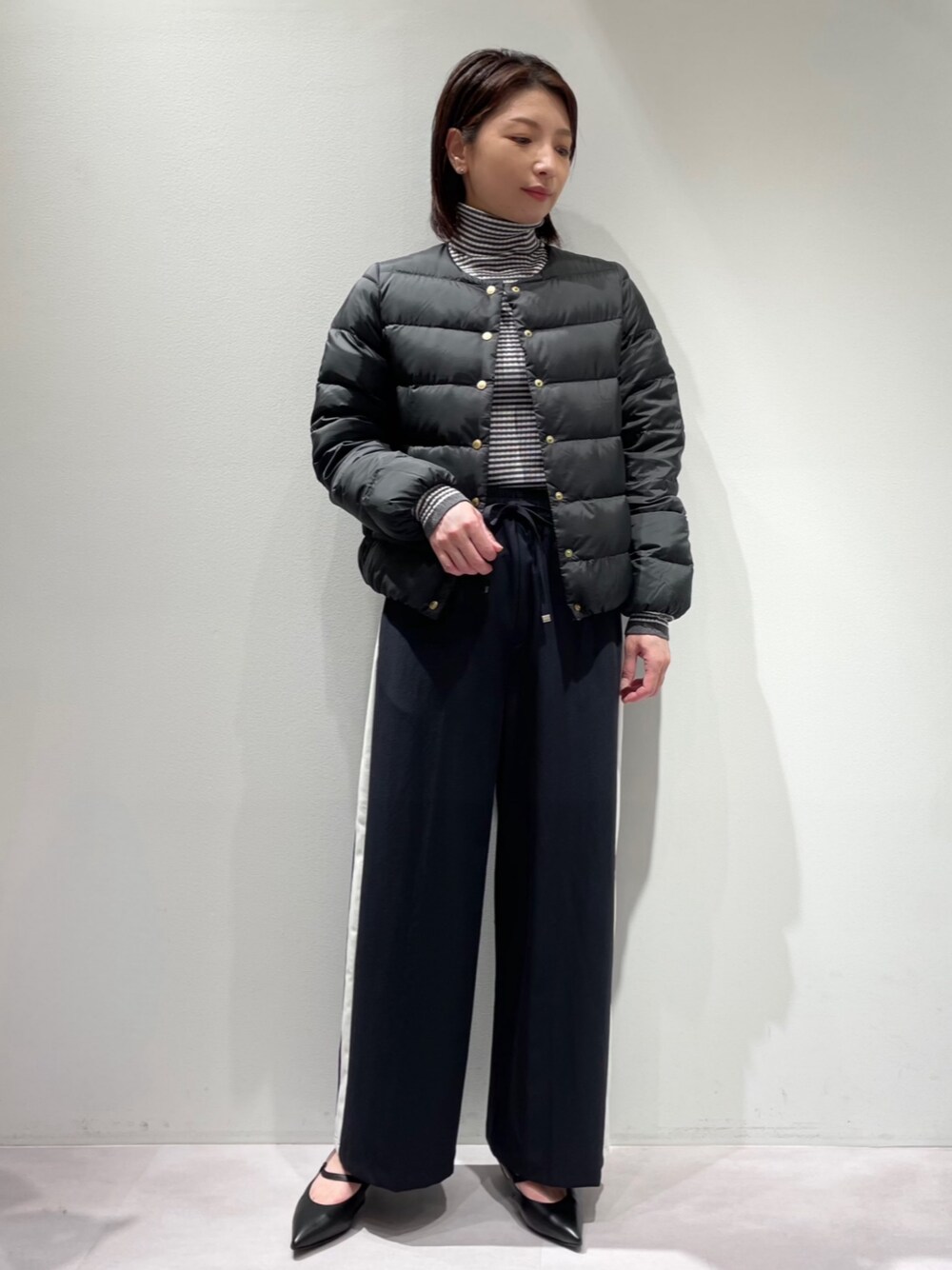ブラック系のダウンジャケット/コート、ブルー系のその他パンツ、その他のニット/セーターを着用したレディースの秋コーディネートの1枚目の写真