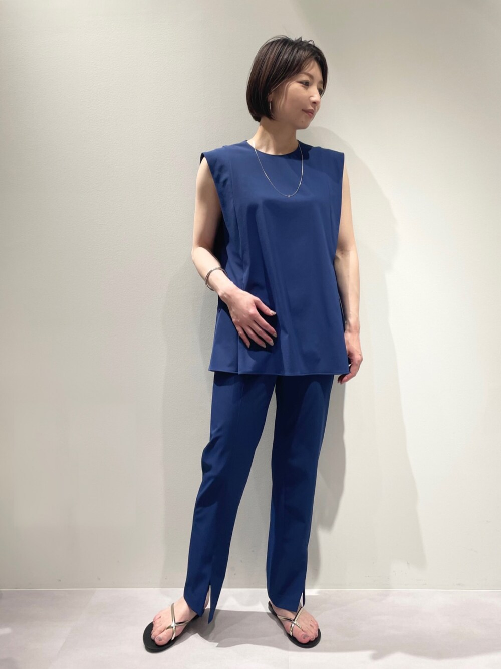 ブルー系のスラックス、ブルー系のシャツ/ブラウス、ゴールド系のネックレスを着用したレディースの夏コーディネートの1枚目の写真