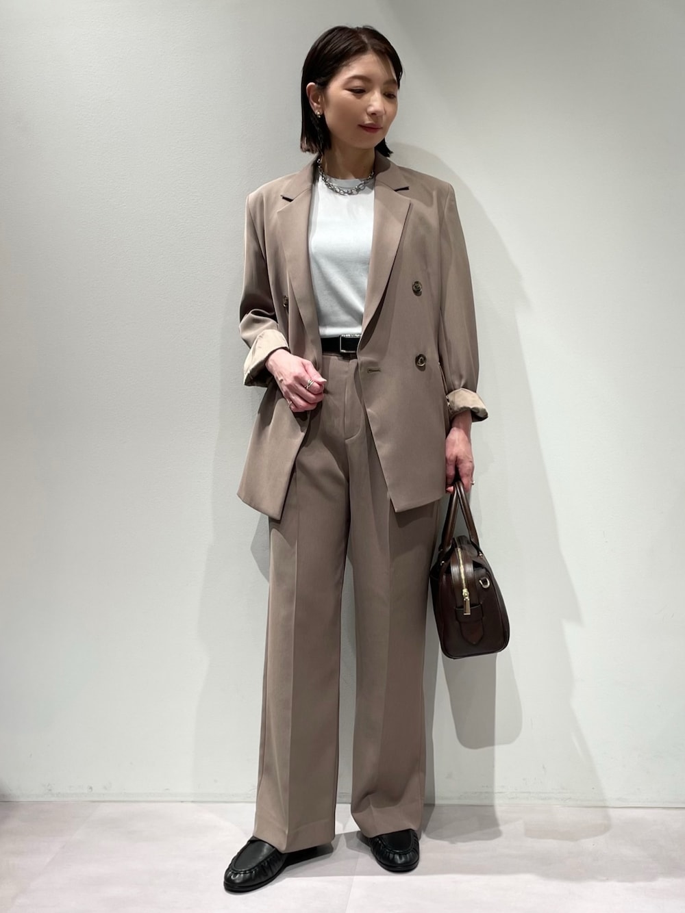 ブラウン系のその他パンツ、ブラウン系のテーラードジャケット、ブルー系のニット/セーターを着用したレディースの秋コーディネートの1枚目の写真