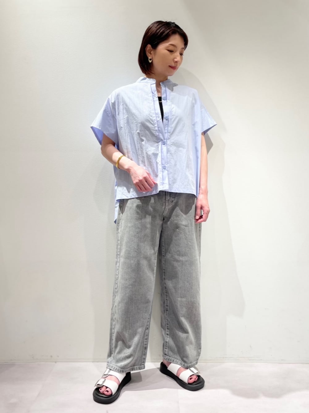 ブラック系のデニムパンツ、ブルー系のシャツ/ブラウス、ホワイト系のパンプスを着用したレディースの夏コーディネートの1枚目の写真