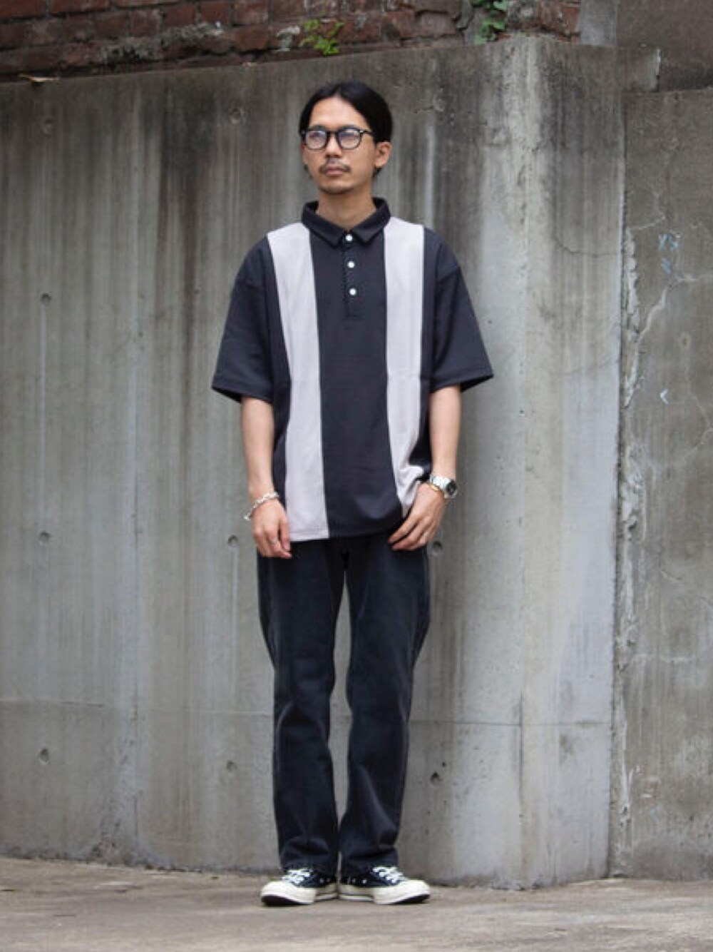 ブラック系のポロシャツ、ブラック系のデニムパンツを着用したメンズの春コーディネートの1枚目の写真