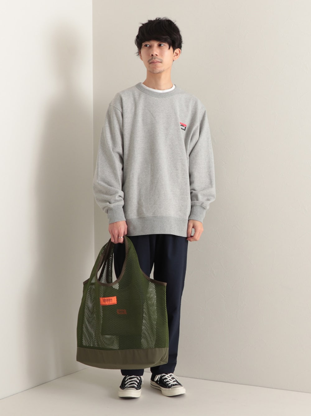 グレー系のスウェット、グリーン系のトートバッグ、ブルー系のその他パンツを着用したメンズの冬コーディネートの1枚目の写真