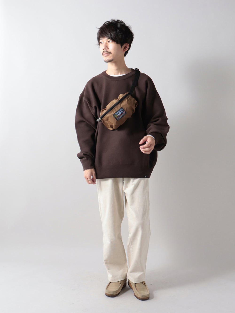 グリーン系のボディバッグ/ウエストポーチ、ブラウン系のニット/セーター、ホワイト系のその他パンツを着用したメンズの秋コーディネートの1枚目の写真