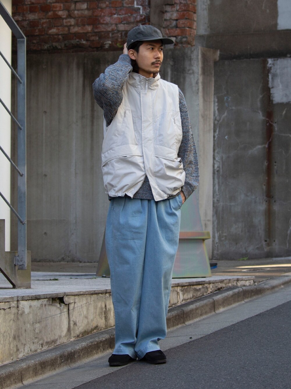 ホワイト系のベスト、ブルー系のその他パンツ、ブラック系のブーツを着用したメンズの冬コーディネートの1枚目の写真