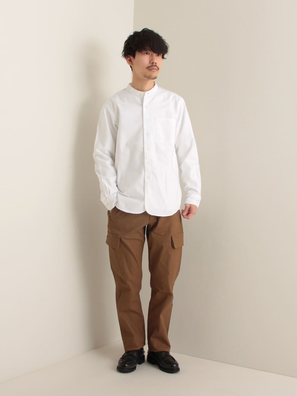 ホワイト系のシャツ/ブラウス、ベージュ系のカーゴパンツ、ブラック系のドレスシューズを着用したメンズの冬コーディネートの1枚目の写真