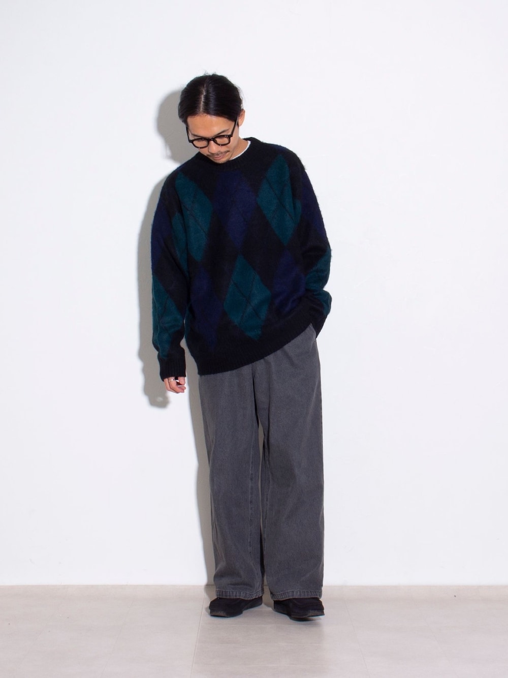 ブラック系のニット/セーター、ブラック系のデニムパンツ、ブラック系のブーツを着用したメンズの秋コーディネートの1枚目の写真