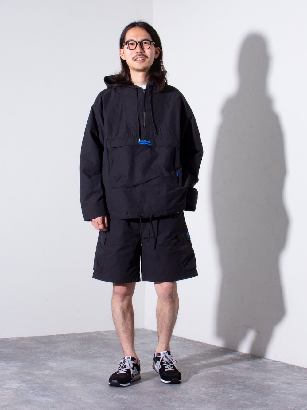 ブラック系のナイロンジャケット、ブラック系のカーゴパンツを着用したメンズの春コーディネートの1枚目の写真