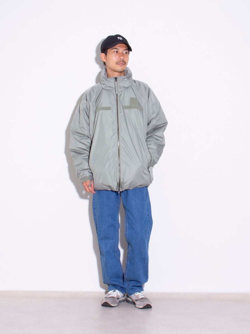 ブルー系のデニムパンツ、グリーン系のダウンジャケット/コートを着用したメンズの秋コーディネートの1枚目の写真