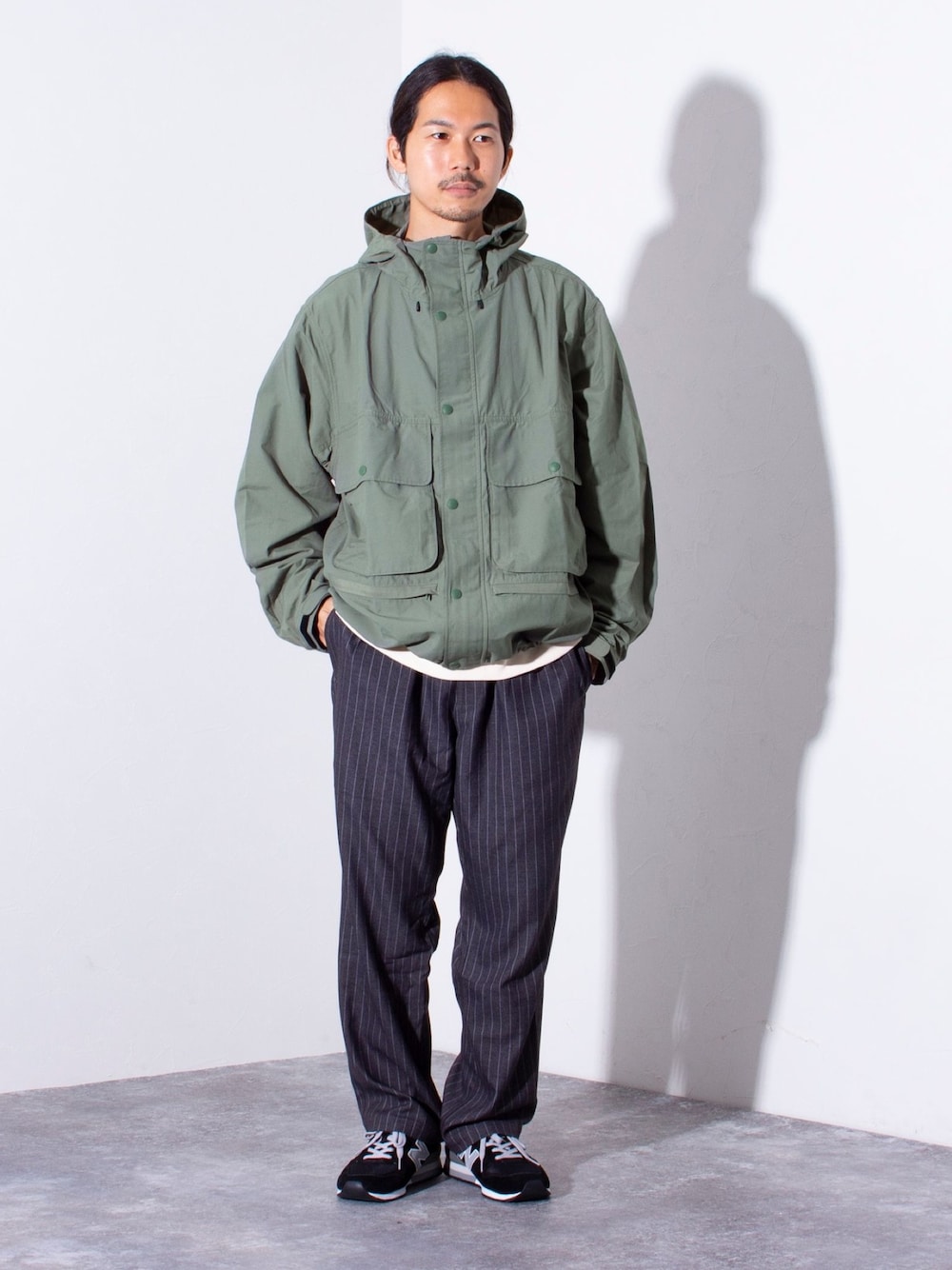 グリーン系のブルゾンを着用したメンズの夏コーディネートの1枚目の写真