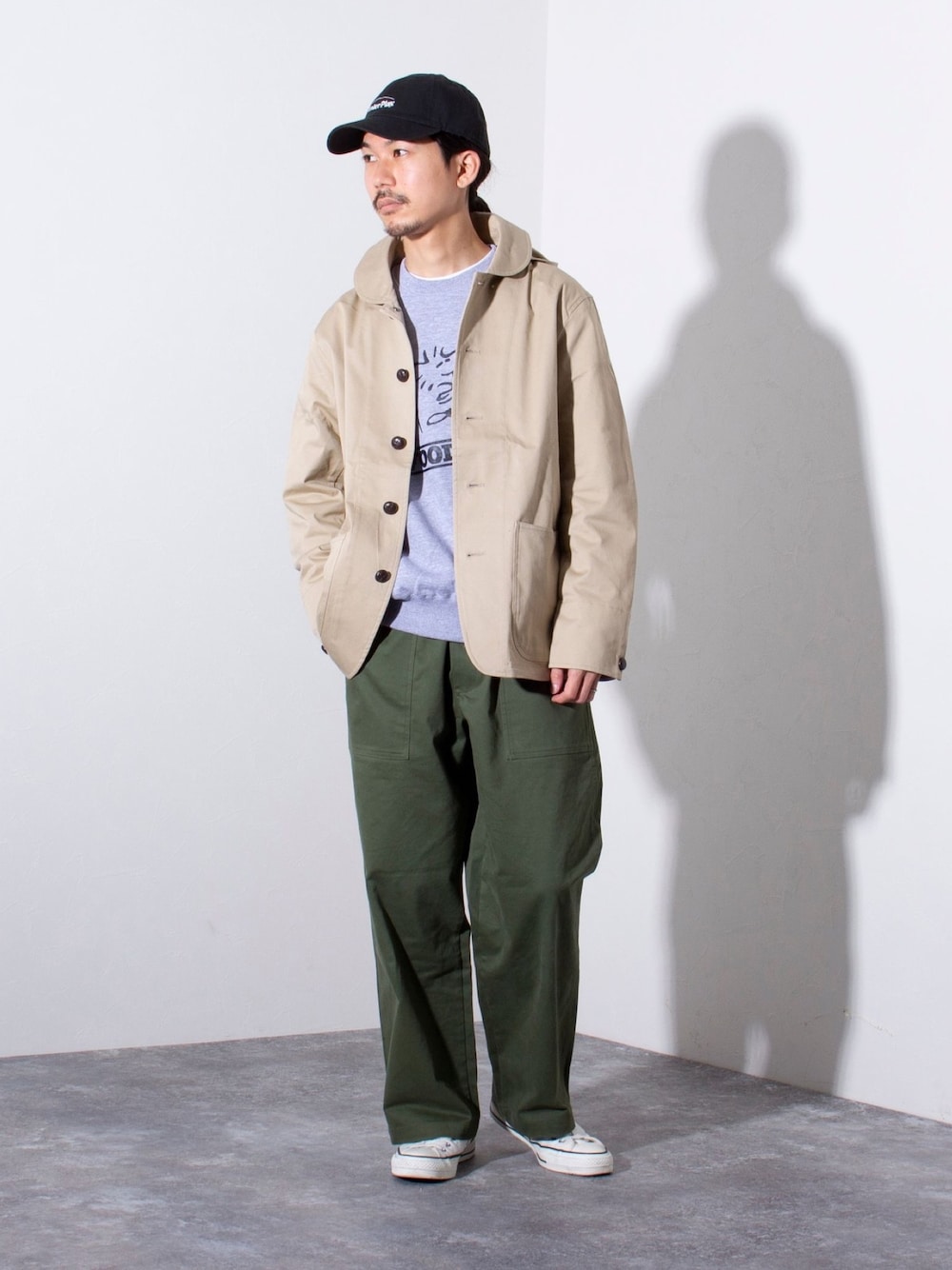 ベージュ系のブルゾン、グリーン系のその他パンツ、ブラック系のキャップを着用したメンズの冬コーディネートの1枚目の写真