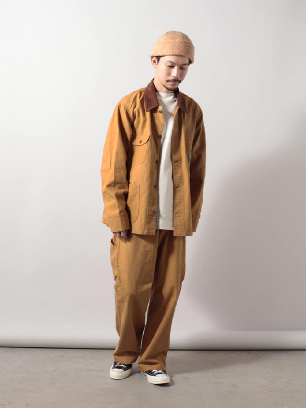 ブラウン系のカバーオール、ホワイト系のTシャツ/カットソー、ブラウン系のその他パンツを着用したメンズの秋コーディネートの1枚目の写真