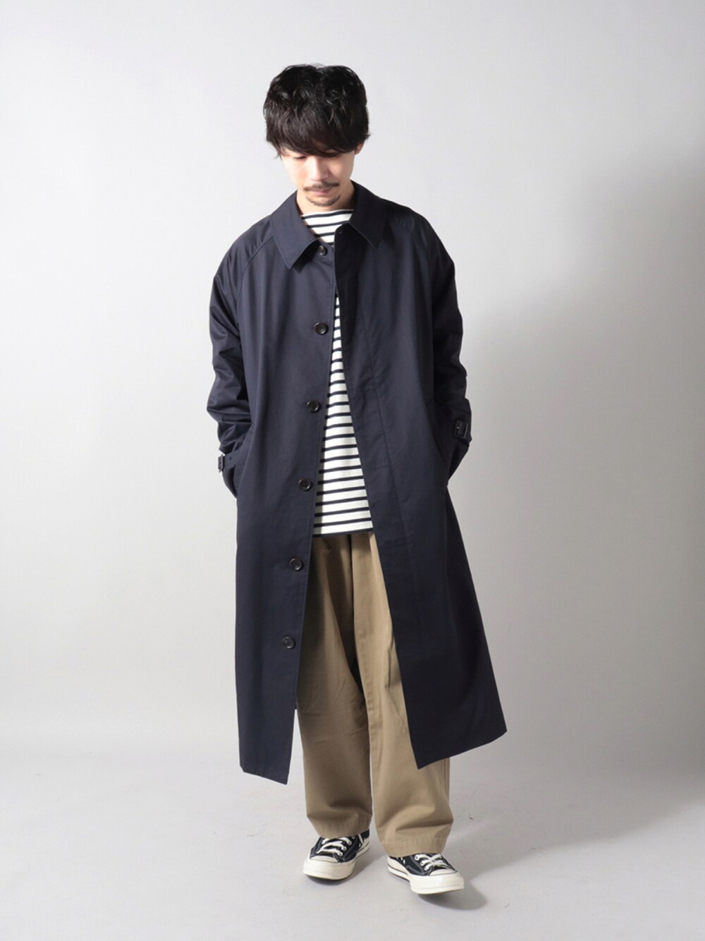 ホワイト系のTシャツ/カットソー、ベージュ系のチノパンツ、ブラック系のスニーカーを着用したメンズの秋コーディネートの1枚目の写真