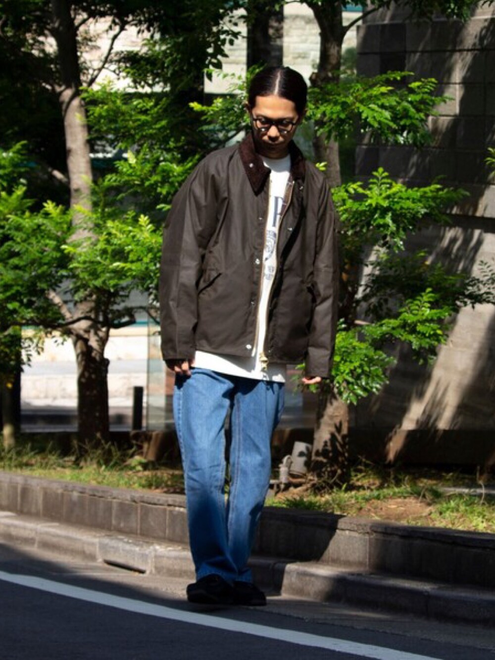 グリーン系のブルゾン、ブルー系のデニムパンツ、ホワイト系のスウェットを着用したメンズの秋コーディネートの1枚目の写真