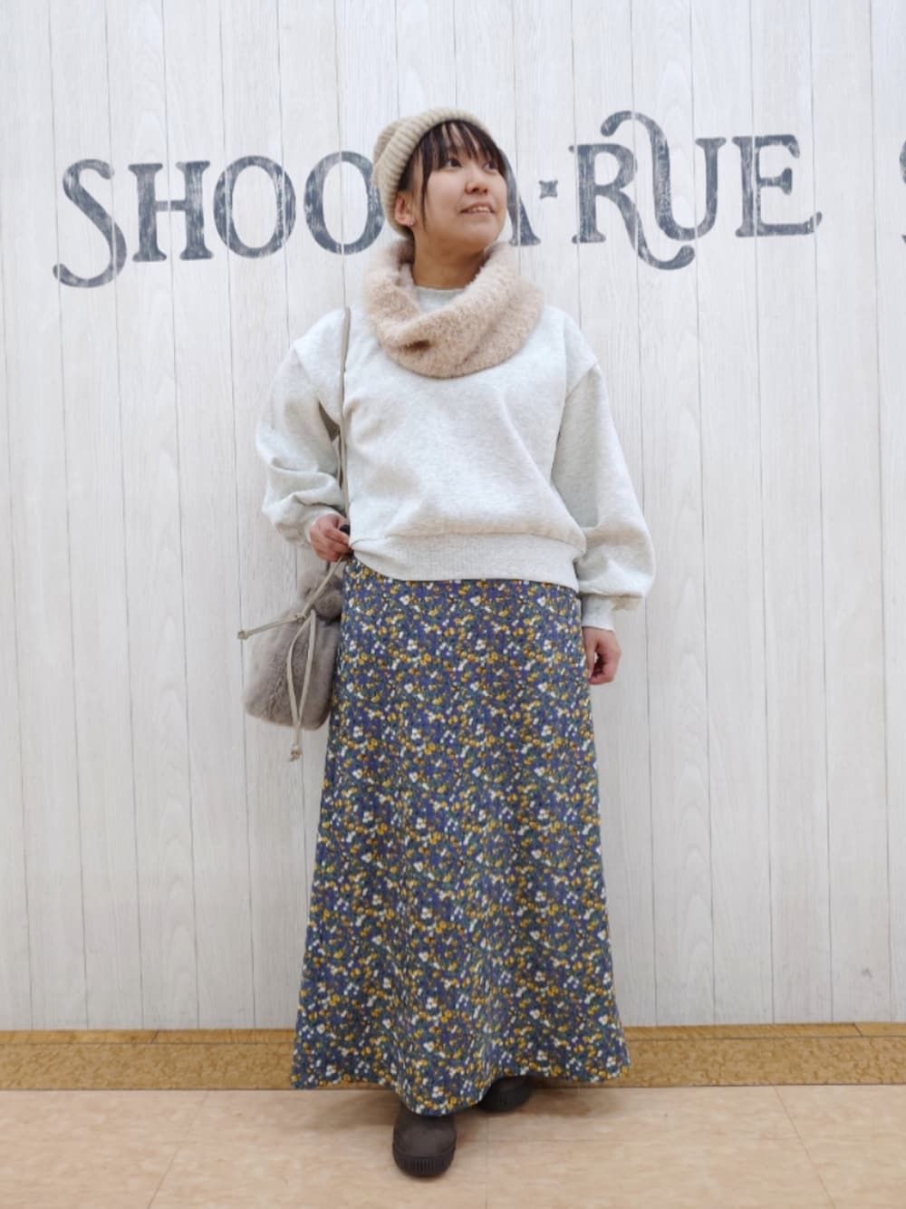 ホワイト系のスウェット、ブラウン系のショルダーバッグ、ブラウン系のブーツを着用したレディースの秋コーディネートの1枚目の写真