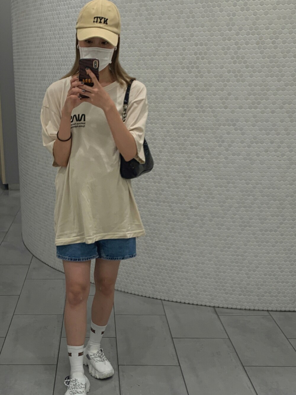 ベージュ系のTシャツ/カットソー、ブラック系のバッグ、ブルー系のデニムパンツを着用したレディースの夏コーディネートの1枚目の写真