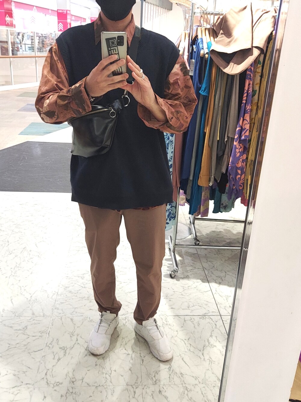 ホワイト系のスニーカー、ブルー系のベスト、シルバー系のリングを着用したメンズの春コーディネートの2枚目の写真