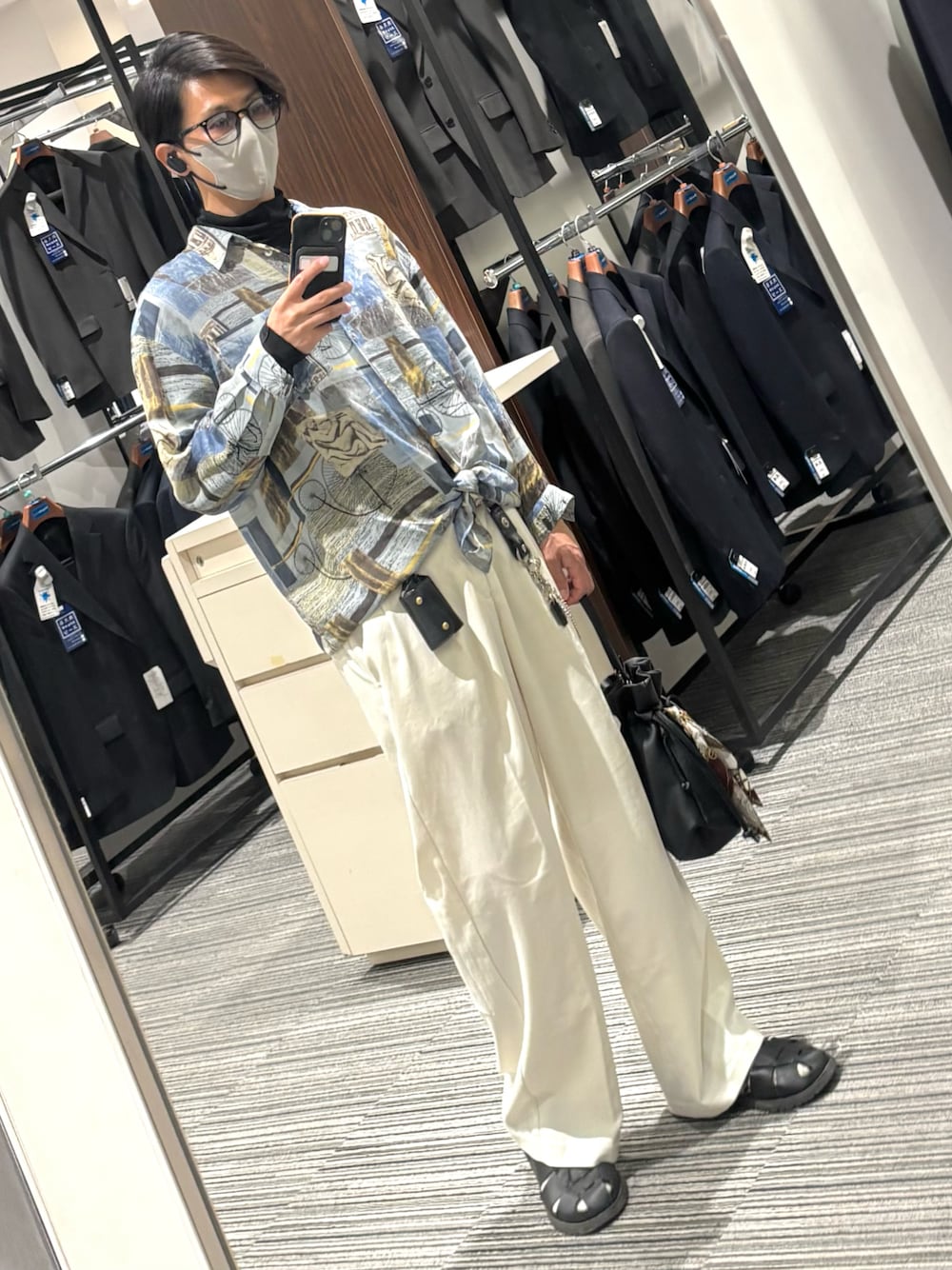 ホワイト系のスラックス、ブラック系のTシャツ/カットソー、ブラック系のサンダルを着用したメンズの夏コーディネートの1枚目の写真