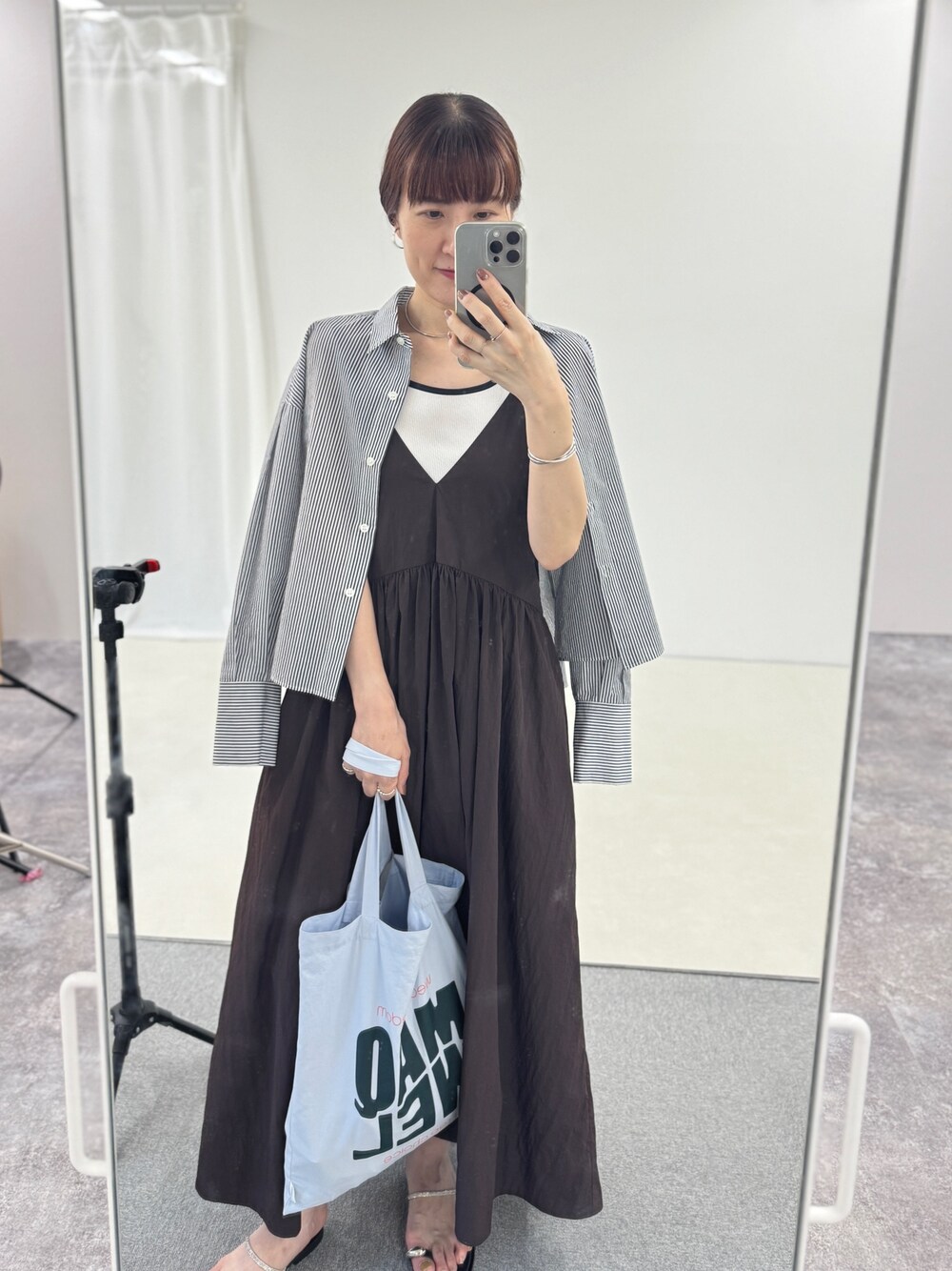 ブルー系のトートバッグ、シルバー系のサンダル、ブラウン系のワンピースを着用したレディースの夏コーディネートの1枚目の写真