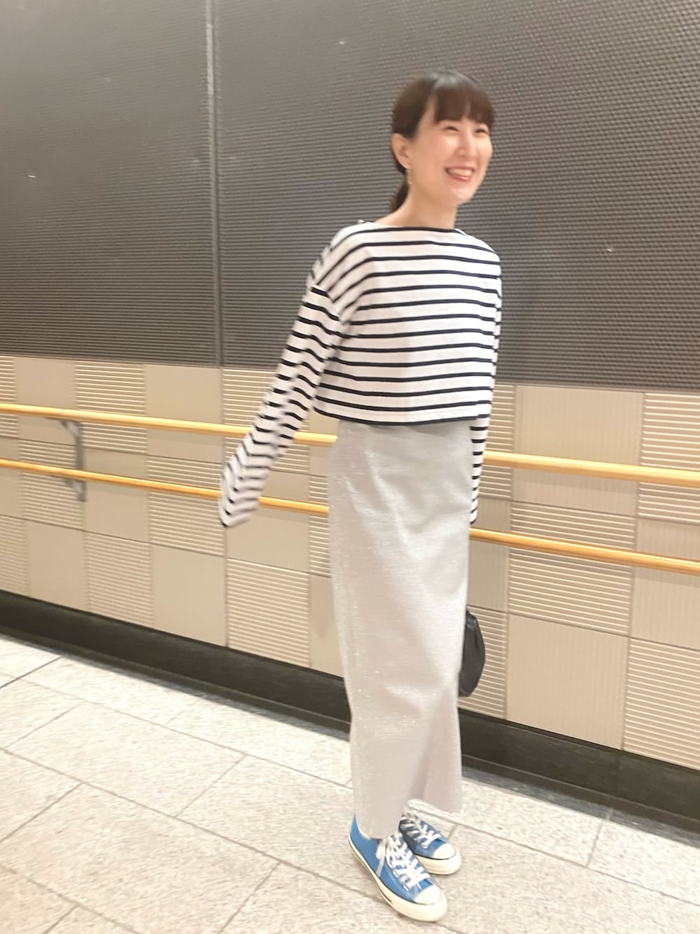 ピンク系のTシャツ/カットソー、シルバー系のスカート、ブルー系のスニーカーを着用したレディースの春コーディネートの1枚目の写真