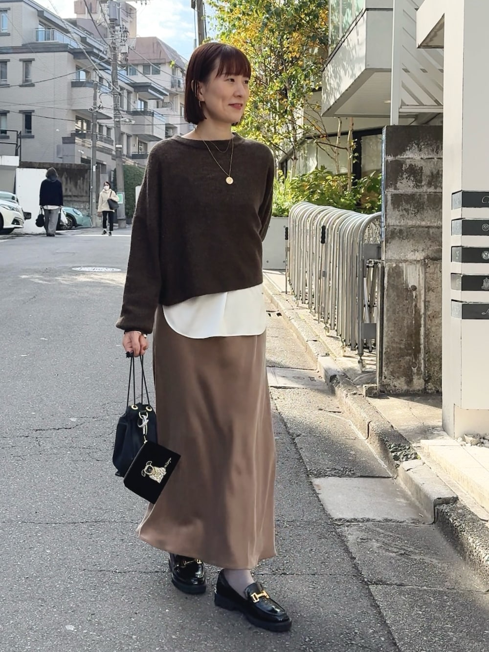 ホワイト系のシャツ/ブラウス、ブラウン系のニット/セーター、ブラック系のその他シューズを着用したレディースの冬コーディネートの1枚目の写真