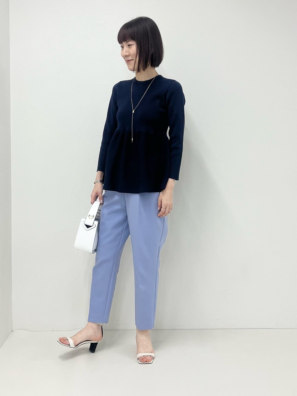 ブルー系のその他パンツ、ホワイト系のショルダーバッグ、ブルー系のニット/セーターを着用したレディースの冬コーディネートの1枚目の写真