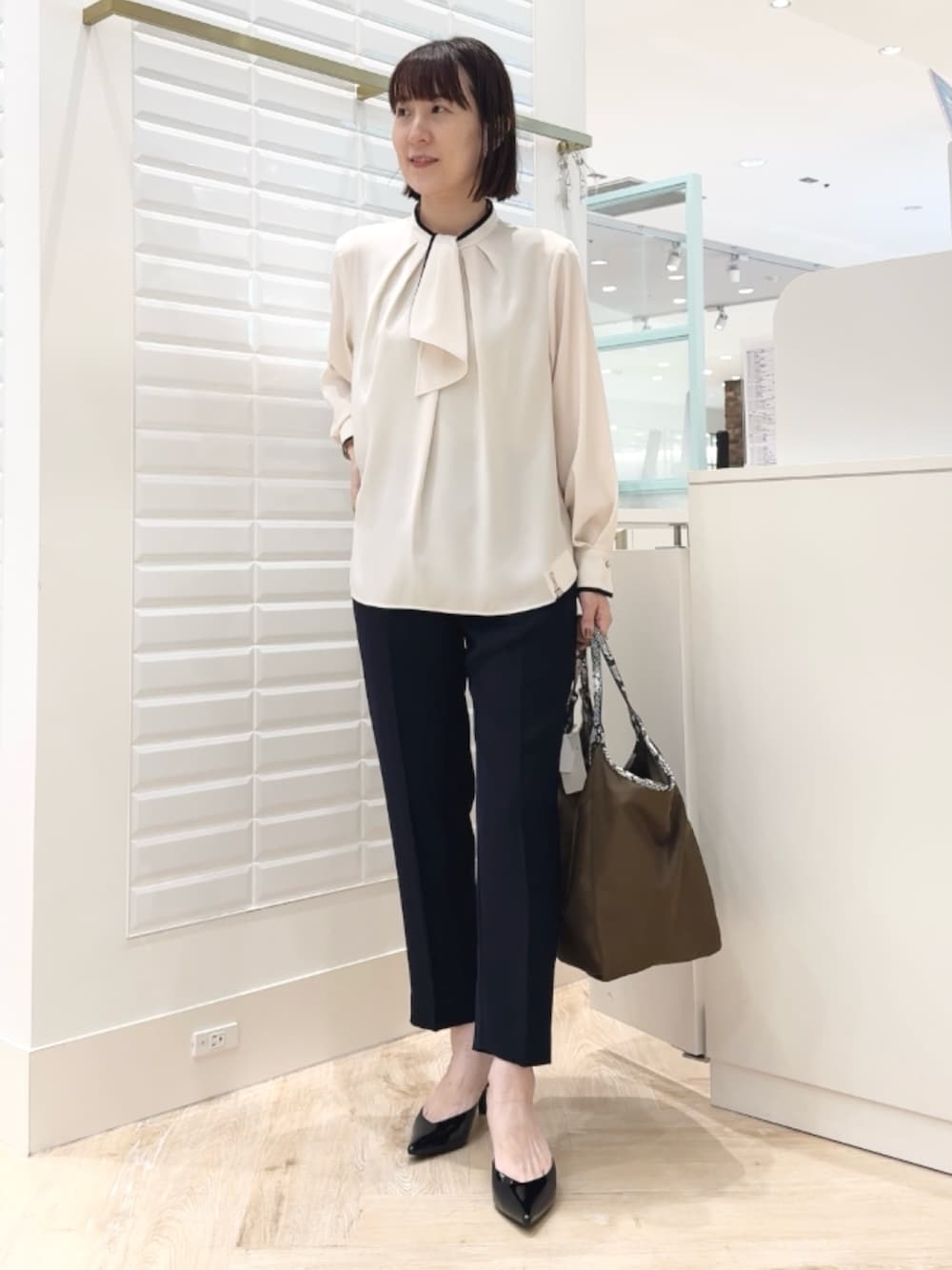 ブルー系のその他パンツ、ブラウン系のトートバッグ、ホワイト系のシャツ/ブラウスを着用したレディースの秋コーディネートの1枚目の写真