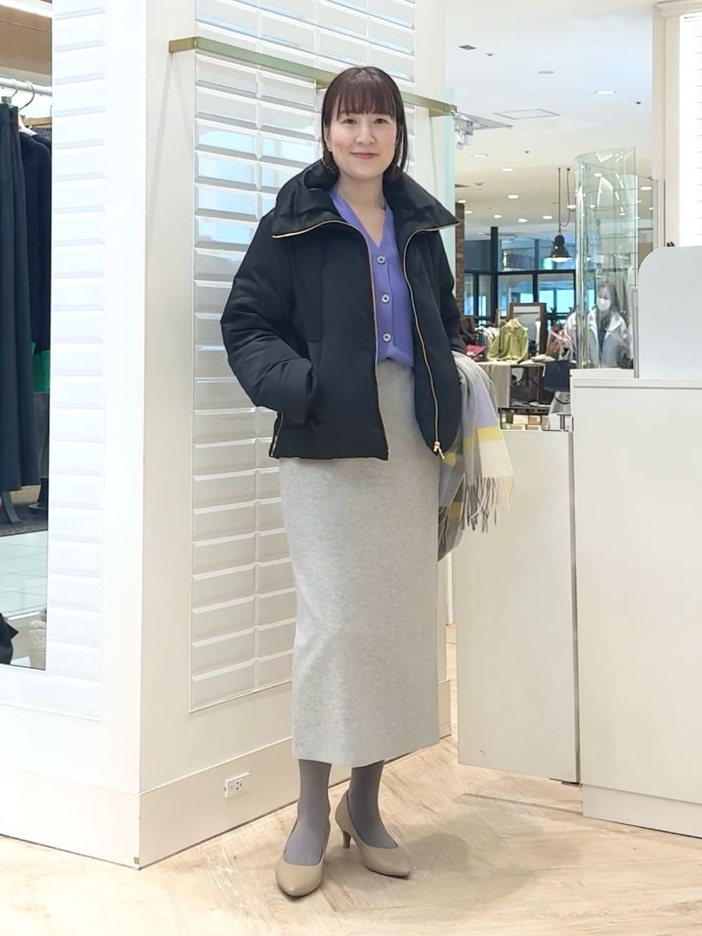 ブラック系のダウンジャケット/コート、パープル系のカーディガン/ボレロ、グレー系のスカートを着用したレディースの秋コーディネートの1枚目の写真