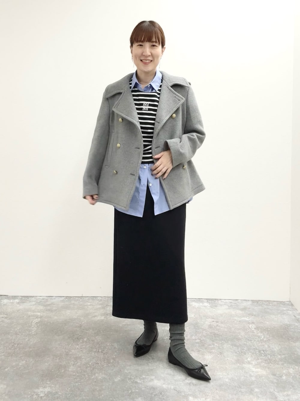 ブラック系のスカート、ブラック系のTシャツ/カットソー、グレー系のピーコートを着用したレディースの秋コーディネートの1枚目の写真