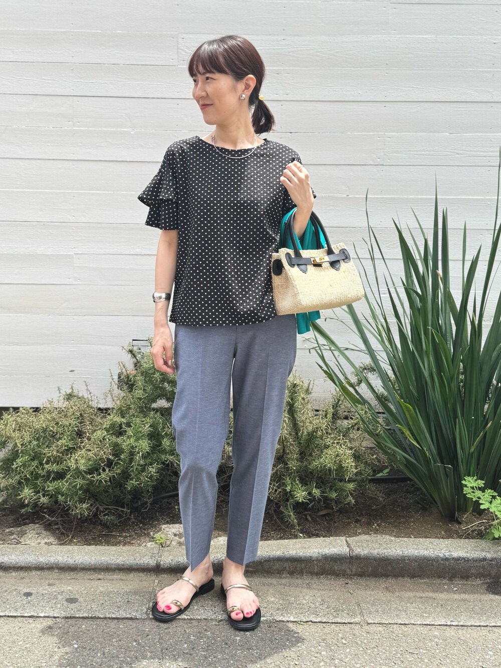 ゴールド系のサンダル、ブルー系のその他パンツ、ブラック系のかごバッグを着用したレディースの春コーディネートの1枚目の写真