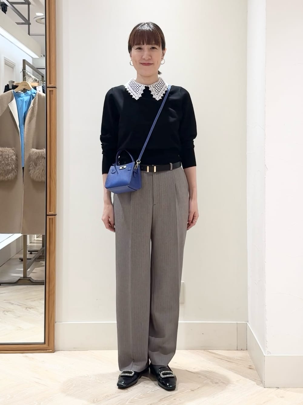 ブラウン系のその他パンツ、ブルー系のショルダーバッグ、ブラック系のニット/セーターを着用したレディースの秋コーディネートの1枚目の写真