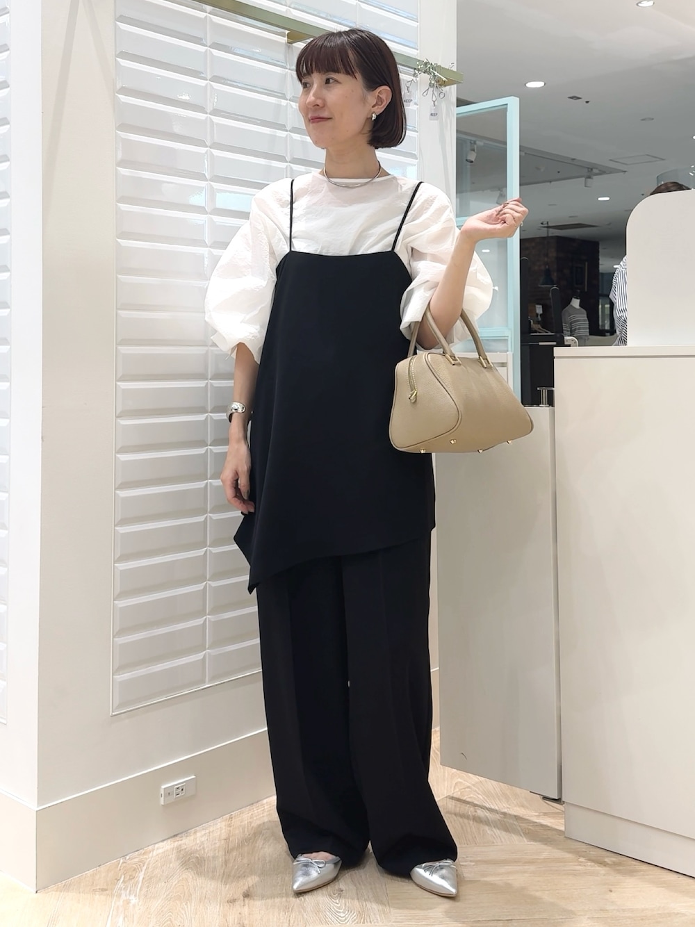 ブラック系のその他パンツ、ホワイト系のシャツ/ブラウス、ベージュ系のショルダーバッグを着用したレディースの秋コーディネートの1枚目の写真