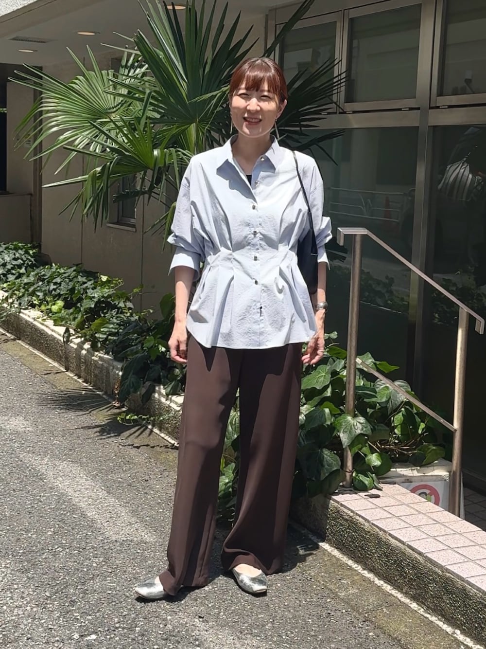 ブラウン系のその他パンツ、ブルー系のシャツ/ブラウス、ブラック系のショルダーバッグを着用したレディースの夏コーディネートの1枚目の写真