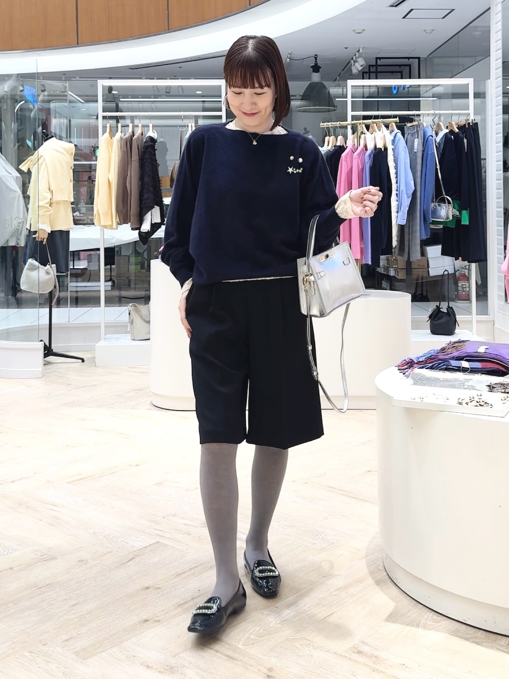 ブルー系のニット/セーター、ブラック系のその他パンツ、ホワイト系のカーディガン/ボレロを着用したレディースの冬コーディネートの1枚目の写真