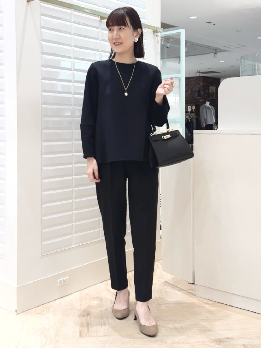 ブラック系のショルダーバッグ、ブラック系のその他パンツ、ブラック系のTシャツ/カットソーを着用したレディースの冬コーディネートの1枚目の写真