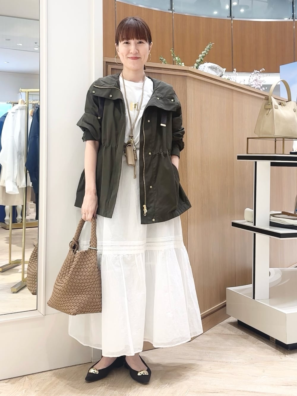 ブラウン系のショルダーバッグ、グレー系のブルゾン、ホワイト系のTシャツ/カットソーを着用したレディースの春コーディネートの1枚目の写真