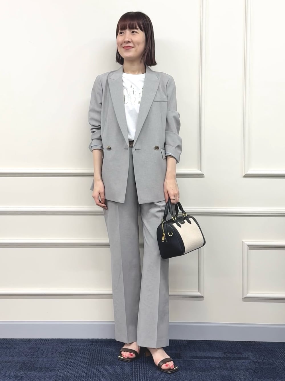 ブラック系のボストンバッグ、グレー系のその他パンツ、ホワイト系のTシャツ/カットソーを着用したレディースの春コーディネートの1枚目の写真